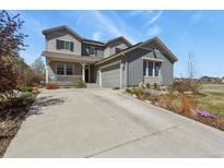 Charming two-story home featuring a covered porch, manicured landscaping, and an attached two-car garage at 1794 Wright Dr, Erie, CO 80516