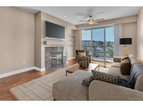 Bright living room with fireplace, TV, and balcony access offers a relaxing and modern living space at 9019 E Panorama Cir # D217, Englewood, CO 80112