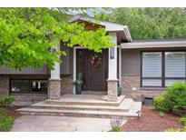 Inviting front door with stone accents, white pillars, and colorful floral wreath detail at 5752 S Jasmine St, Greenwood Village, CO 80111