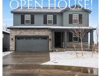 Charming two-story home featuring stone accents, gray siding, and a two-car garage, perfect for suburban living at 1945 S Coolidge Way, Aurora, CO 80018