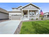 Charming home featuring a quaint front porch, well-manicured lawn, and an attached two-car garage at 17765 Faraday St, Broomfield, CO 80023
