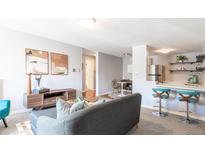 Inviting living room featuring a modern sofa, stylish decor, and open layout to the dining and kitchen area at 1260 York St # 204, Denver, CO 80206