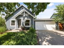 Charming home with a well-manicured lawn, lovely landscaping, and an attached two-car garage at 4860 S Salida Ct, Aurora, CO 80015
