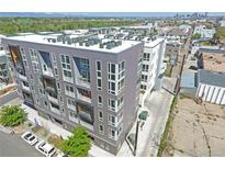 Modern apartment building with sleek gray facade, balconies, and a rooftop filled with HVAC units at 1898 S Bannock St # 103, Denver, CO 80223