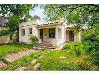 Charming single-story home featuring a stucco exterior, decorative windows, and a tile roof at 130 S Humboldt St, Denver, CO 80209