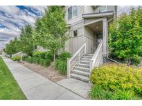 Inviting entrance with concrete steps, white railings, and manicured landscaping at 7277 W Adriatic Cir, Lakewood, CO 80227