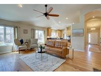 Inviting living room flows to kitchen, featuring hardwood floors and bright natural light at 13941 E Whitaker Dr, Aurora, CO 80015
