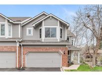 Charming townhome with gray siding, brick accents, and a well-maintained front yard, perfect for comfortable living at 7712 S Monaco E Cir, Centennial, CO 80112