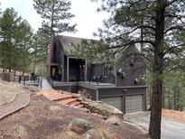 Stunning exterior featuring multi-level deck and stairs surrounded by beautiful trees at 160 Bristlecone Way, Boulder, CO 80304