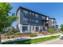 Contemporary townhouse with gray siding, white trim, a small porch, and a well-maintained front yard at 2080 Alcott Way, Broomfield, CO 80023