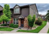 Charming two-story townhome with brick and wood exterior, front yard landscaping, and covered entryway at 3855 S Monaco St # 177, Denver, CO 80237
