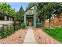 Charming two-story home with a welcoming yellow door and well-maintained landscaping at 2089 S Washington St, Denver, CO 80210