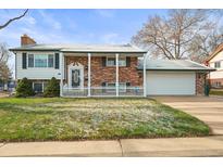 Charming two-story brick home with a covered front porch and a well-manicured lawn at 10805 Verna Ln, Northglenn, CO 80234