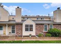 Charming townhome with brick accents, beige siding, and well-maintained landscaping at 8304 S Upham Way, Littleton, CO 80128