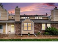 Charming townhome featuring brick and siding, landscaped grounds, and a cozy, welcoming entrance at 8304 S Upham Way, Littleton, CO 80128