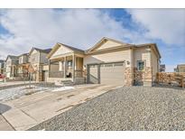 Charming single-Gathering home featuring a two-car garage, covered front porch, and gravel landscaping at 45831 Silverdrop Ave, Bennett, CO 80102