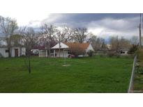 A spacious backyard with lush green grass and a charming single-Gathering home; a perfect outdoor space for relaxation and play at 7170 W Mississippi W Ave, Lakewood, CO 80226