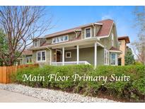 Charming two-story home featuring a welcoming front porch and landscaped front yard with mature hedges at 2595 S Adams St, Denver, CO 80210