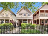 Charming two-story home with a balcony, manicured lawn, and a classic black fence at 2222 N Washington St, Denver, CO 80205