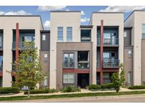 Modern townhome featuring balconies, stucco, gray brick and landscaped front yard at 538 S Upham St, Lakewood, CO 80226