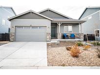 Charming single-story home with a two-car garage and a cozy front porch with stone accents at 121 S Vandriver Way, Aurora, CO 80018