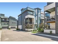 Modern townhome with stylish architecture, blue and white color scheme, and well-maintained landscaping at 6791 Navajo Ct, Denver, CO 80221
