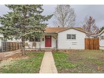 Charming single-story home with a red front door, lovely landscaping, and a cozy front porch with seating at 7665 Meade St, Westminster, CO 80030