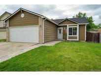 Charming single-Gathering home showcasing a well-maintained lawn and a two-car garage at 13072 Westlake Pl, Broomfield, CO 80020