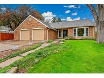 Charming brick home features a well-manicured lawn, a two-car garage, and a welcoming walkway leading to the front door at 7583 S Xanthia Ct, Centennial, CO 80112