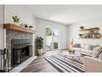 Bright living room features a stone fireplace, wood mantle and sliding door access to the outside at 1707 Ostia Cir # 46, Lafayette, CO 80026