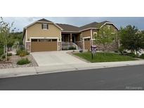Inviting exterior of a two-story home with a well-manicured lawn, stone accents, and a spacious two-car garage at 3855 Old Oaks St, Castle Rock, CO 80104