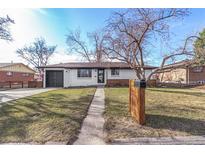 Charming single-story home featuring a well-maintained front yard and a convenient attached garage at 2840 Cottonwood Dr, Denver, CO 80221