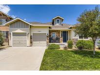 Charming single-Gathering home featuring a well-manicured lawn, stone accents, and a two-car garage at 21855 E Idyllwilde Dr, Parker, CO 80138