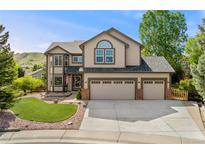 Charming two-story home featuring a three-car garage, landscaped front yard, and classic architectural details at 1825 Cooper Ct, Castle Rock, CO 80109
