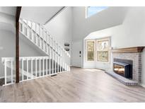 Inviting living room features a fireplace, white staircase, and plenty of natural light at 1740 S Ammons St # C, Lakewood, CO 80232