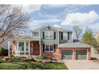 Charming two-story home featuring a manicured lawn, brick accents, and an attached two-car garage at 674 Huntington Dr, Highlands Ranch, CO 80126