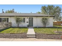 Charming home featuring a white brick facade, well-maintained lawn, and a neatly landscaped front yard at 1087 Wolff St, Denver, CO 80204