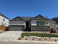 Charming single-Gathering home with a two-car garage, a modern stone accent, and beautifully manicured landscaping at 16655 W 93Rd Pl, Arvada, CO 80007