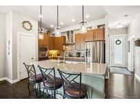 Well-lit kitchen boasts stainless steel appliances, center island, and sleek countertops for modern living at 1857 W 67Th Pl, Denver, CO 80221