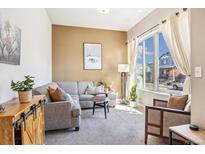 Comfortable living room with a sectional sofa, bright window, and stylish decor at 1857 W 67Th Pl, Denver, CO 80221