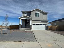 Charming two-story home featuring stone accents, a two-car garage, and a well-maintained lawn at 9446 Yampa Ct, Commerce City, CO 80022