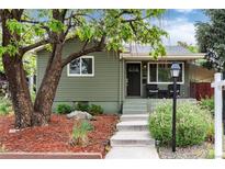 Charming home featuring a landscaped front yard with a tree and concrete steps leading to the front entrance at 4520 S Delaware St, Englewood, CO 80110