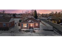 Brick ranch home aerial view, showcasing a snow-covered yard and neighborhood at 501 S Dale Ct, Denver, CO 80219