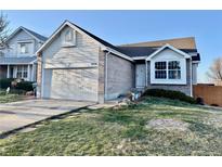 Charming home featuring a manicured front yard, attached garage, and stylish brick and siding exterior at 4036 S Himalaya Cir, Aurora, CO 80013