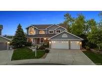 Charming two-story home with a well-manicured lawn, a three-car garage, and beautiful landscaping at 9728 Ashleigh Ln, Highlands Ranch, CO 80126