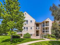 Attractive multi-story condo building with stone accents, balconies, green space, and stairs to upper levels at 7700 N Depew St # 1518, Arvada, CO 80003