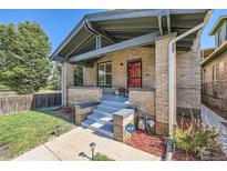 Charming brick home featuring a covered front porch, well-maintained lawn, and beautiful landscaping at 2854 Eliot St, Denver, CO 80211