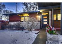 Mid-century modern home with wood siding and snowy yard at 6127 S Westview St, Littleton, CO 80120