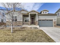 Charming gray two-story home featuring a stone-accented facade, covered entry, and attached garage at 10137 Atlanta St, Parker, CO 80134