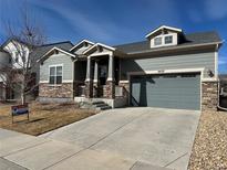 Charming exterior of a home with a well-manicured lawn, stone accents, and a two-car garage at 10137 Atlanta St, Parker, CO 80134